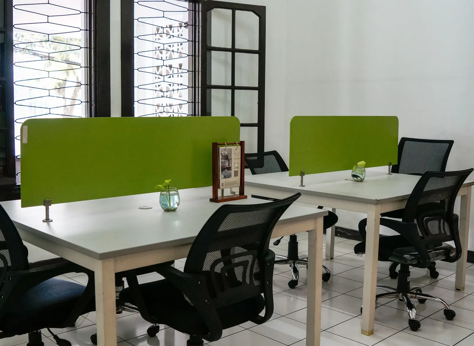Neat and modern co-working office space featuring green dividers and ergonomic chairs. Silent workspace ideas grouped by the noise problem they solve