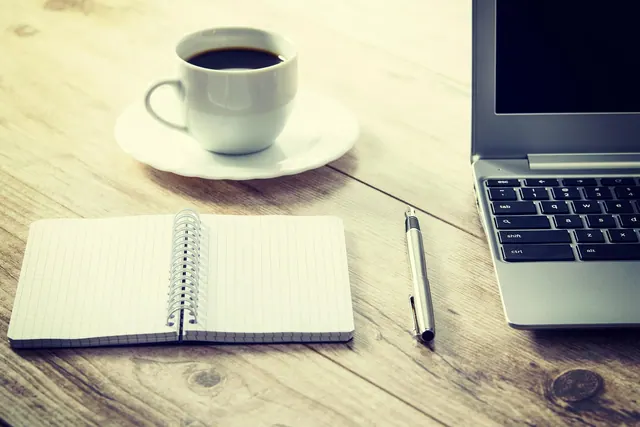 coffee, computer, cup, desk, coffee cup, drink, laptop, notebook, pen, table, wooden table, workspace, work from home